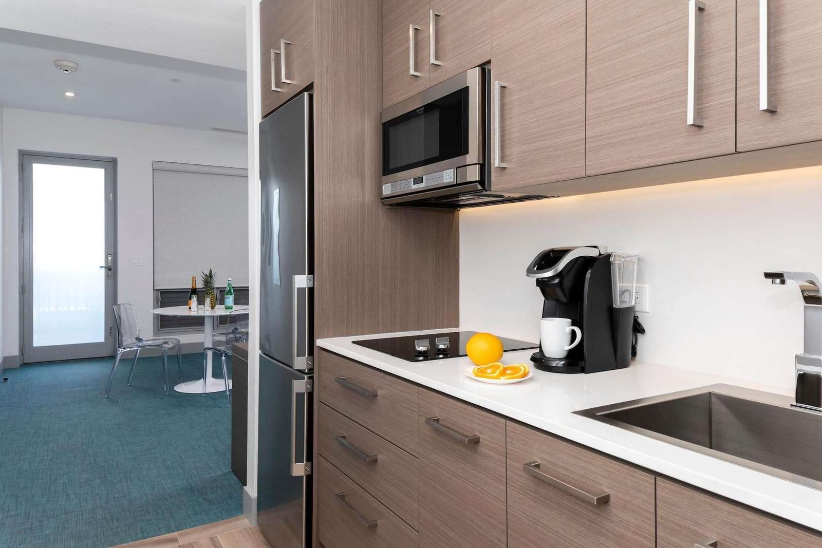 Kitchenette with refrigerator, microwave, cooktop and undermount sink